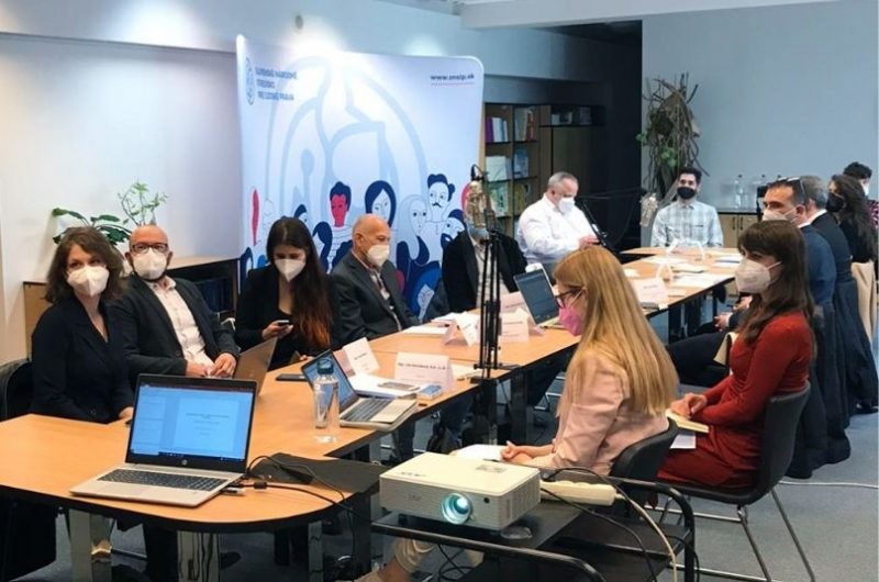 Fotka s podujatia kde účastníci a účastníčky sedia za stolom v knižnici Strediska