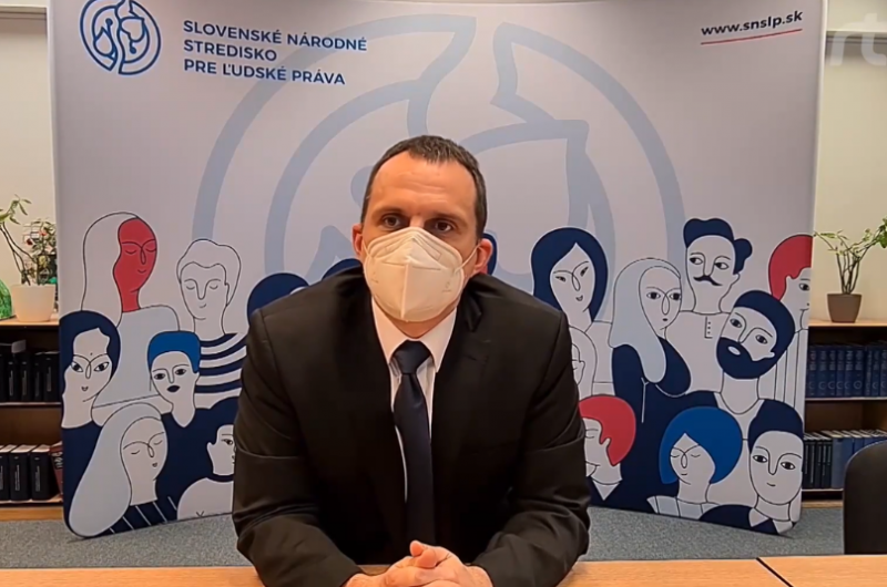 Zamestnanec Strediska sedí za stolom a odpovedá na otázky reportérky